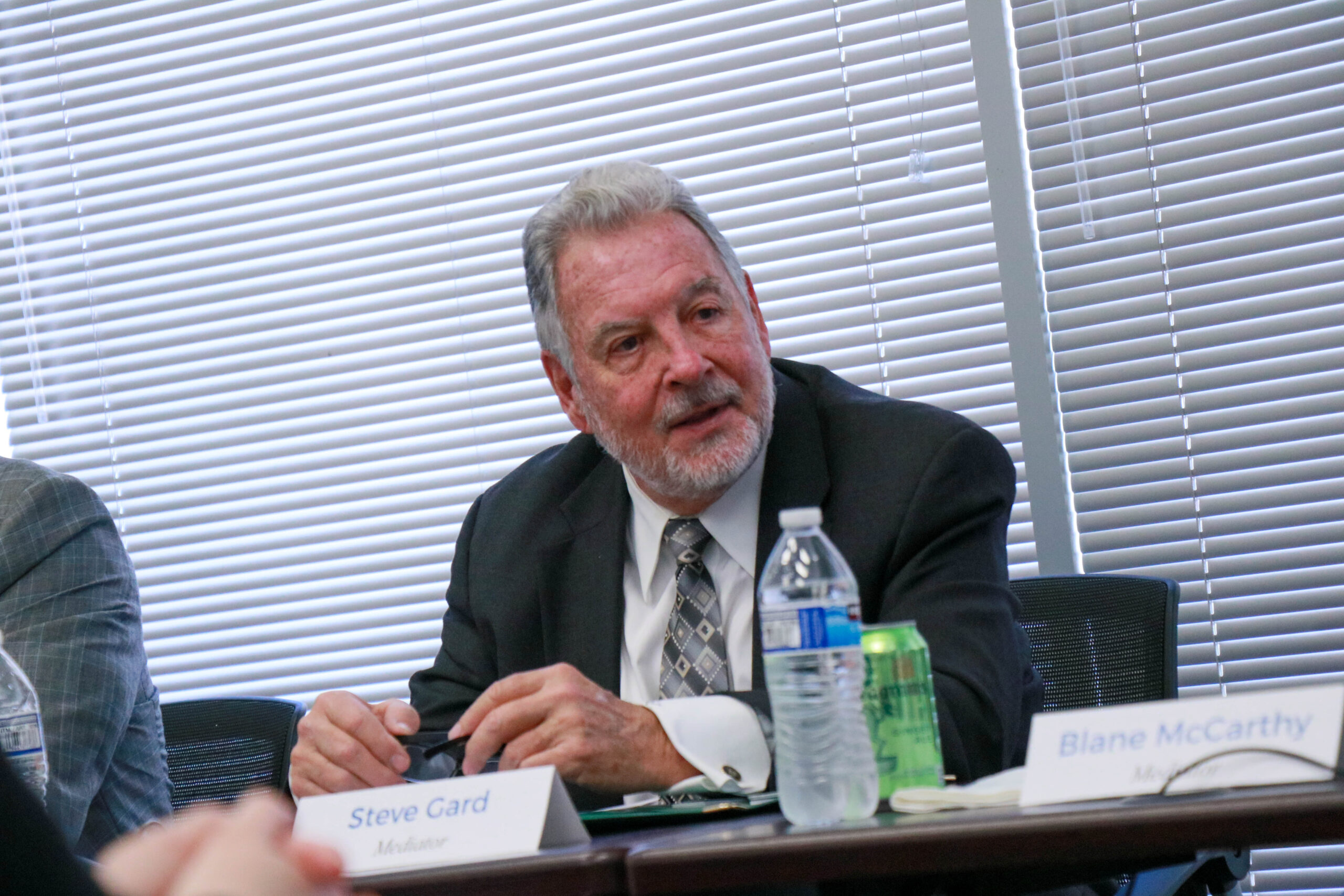 Man in suit discussing at a meeting.